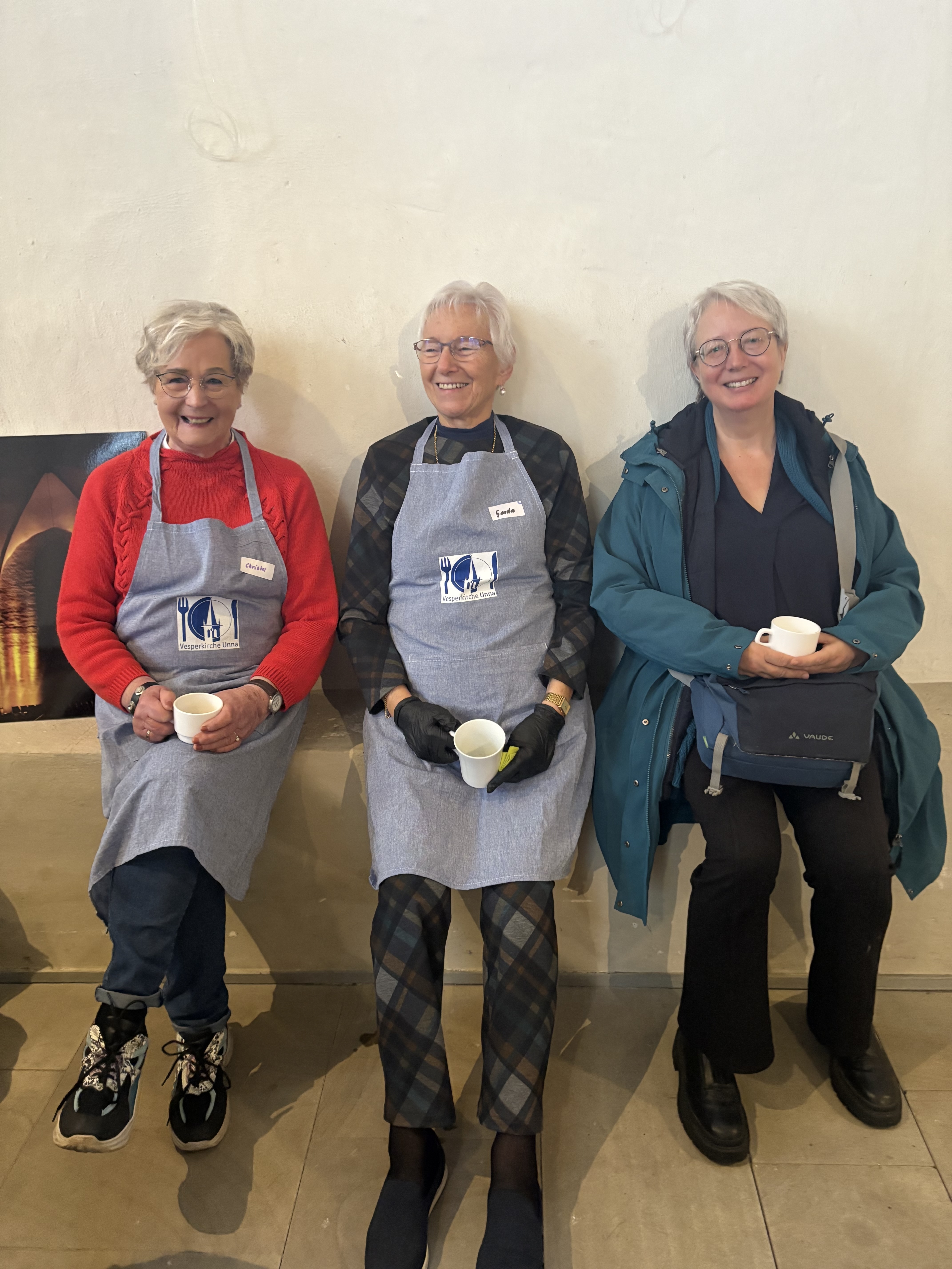 Drei ältere Frauen mit Schürzen