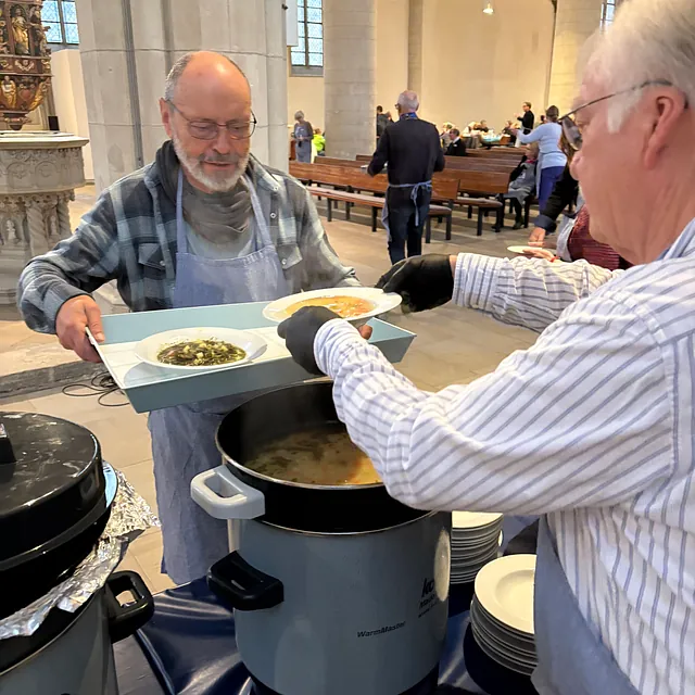 Mann gibt Essen aus Topf