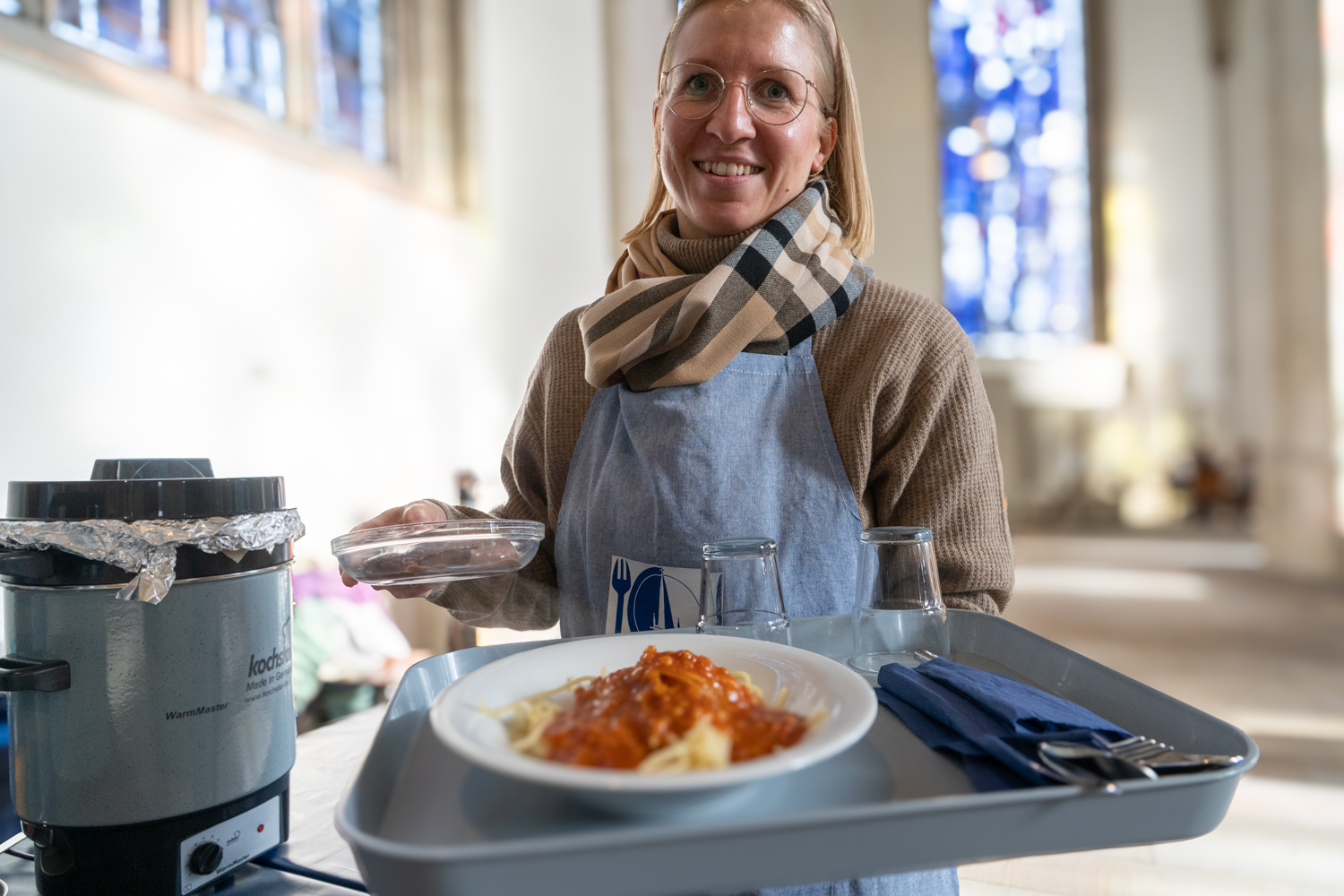 Frau trägt Tablett mit Essen