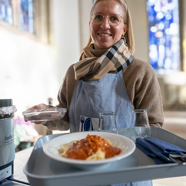 Frau trägt Tablett mit Essen
